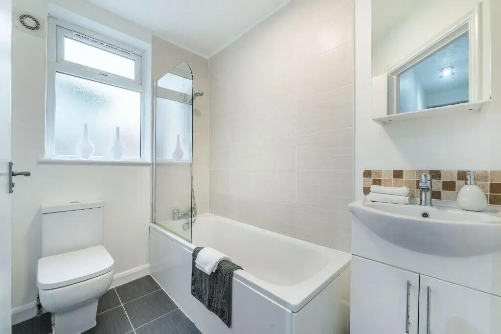 Bright and modern bathroom suite featuring a cl...
