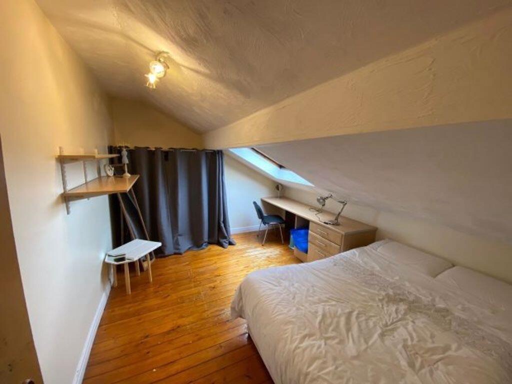 Cozy double bedroom featuring a sloped ceiling ...