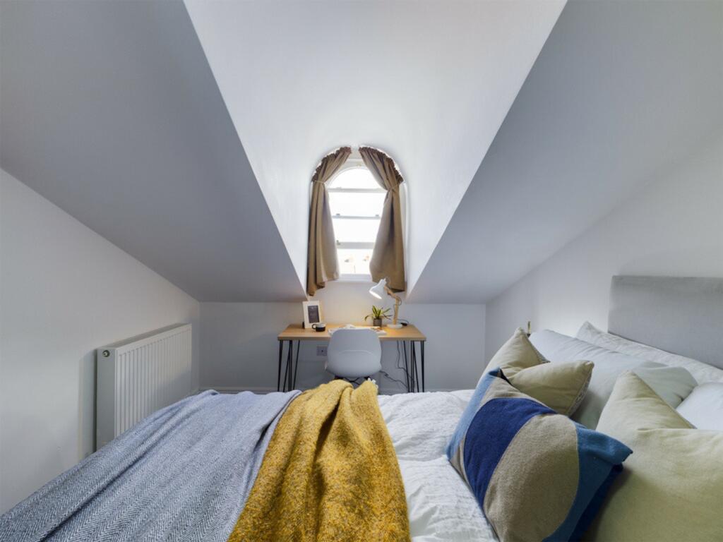 A cozy and well-lit double bedroom with a charm...