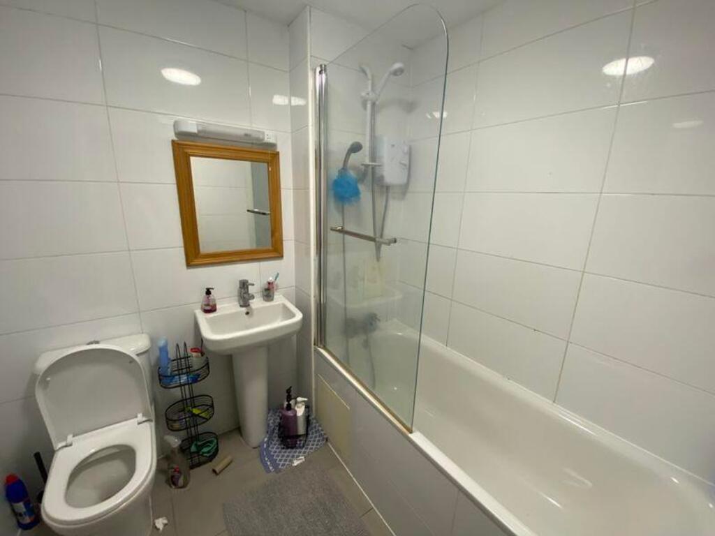 A clean and modern bathroom featuring a bath an...