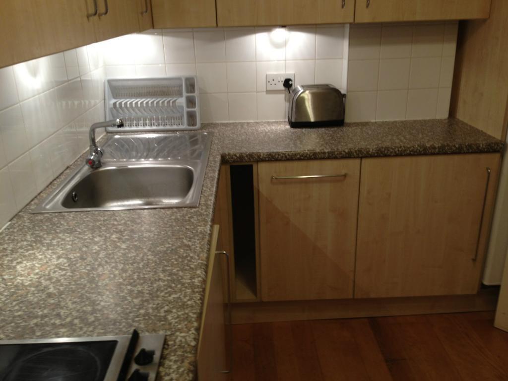 A compact and tidy kitchen featuring wood-effec...