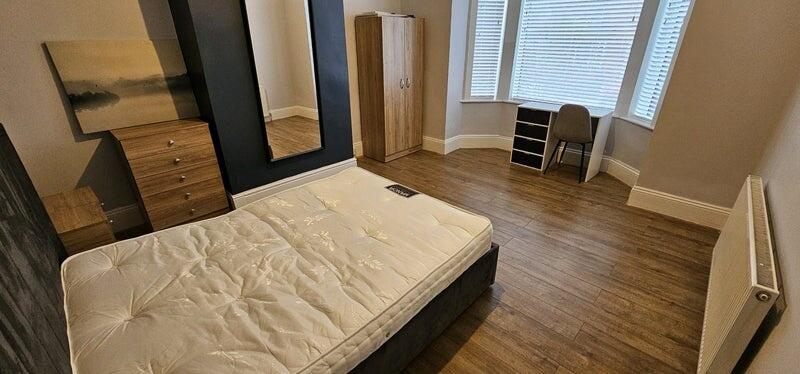 A bright and tidy double bedroom featuring a wo...