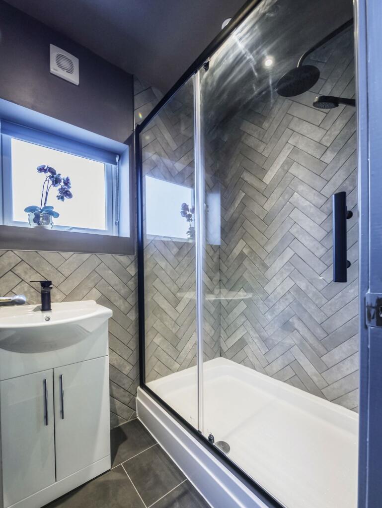 A modern bathroom featuring a sleek walk-in sho...