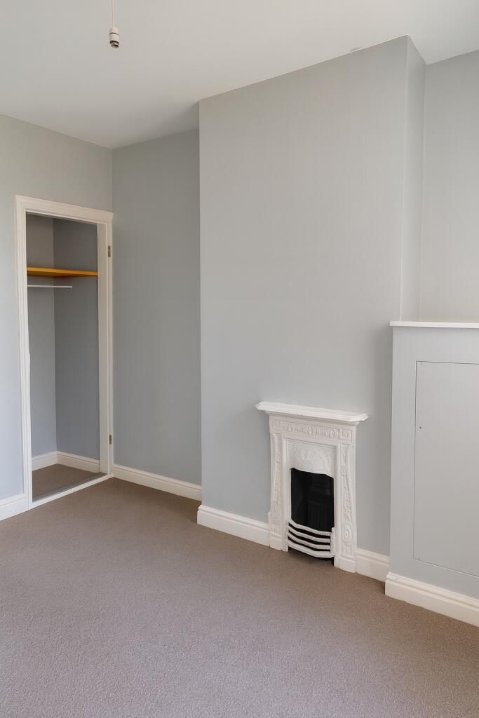 A well-maintained bedroom with light grey walls...