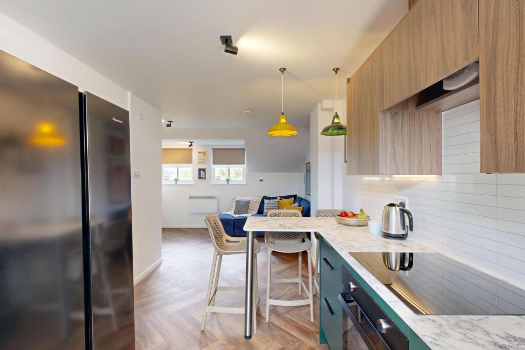 Modern open-plan kitchen with wood-effect cabin...