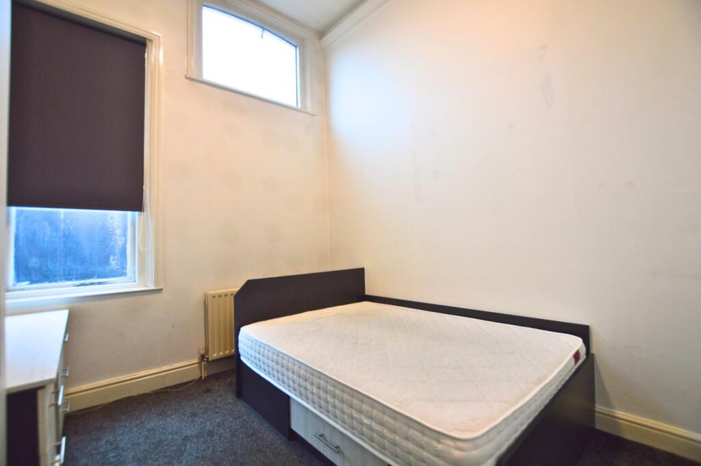 A simple and neat single bedroom featuring a co...