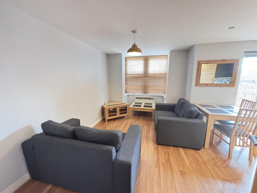 Bright and spacious living room with two comfor...