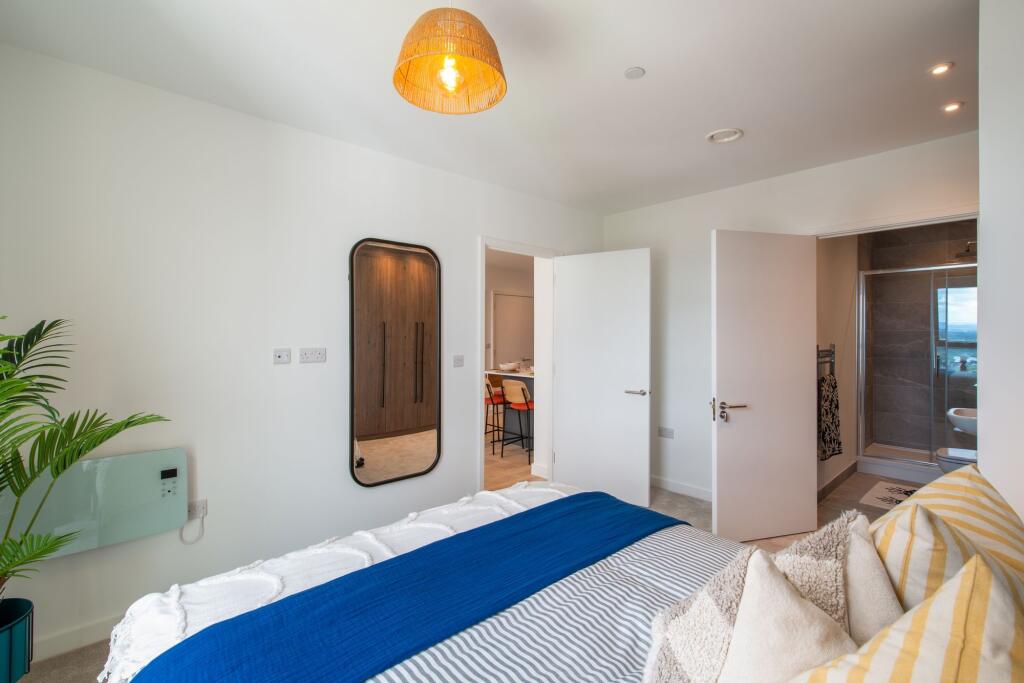 A stylish double bedroom featuring a cozy bed w...