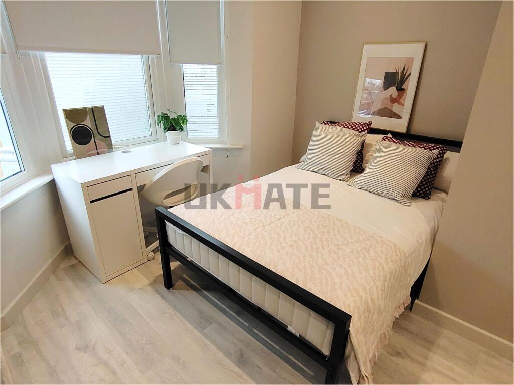 A bright and stylish double bedroom featuring a...