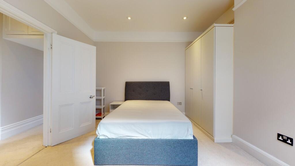 A neat and well-lit double bedroom featuring a ...