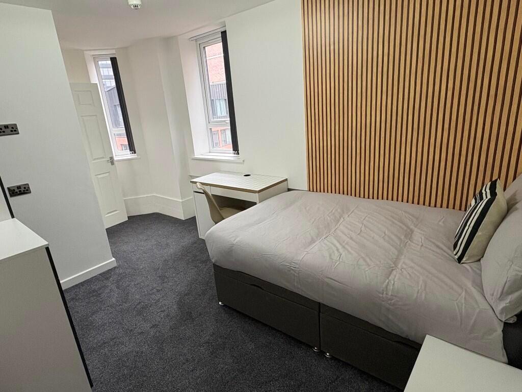 A neat and modern double bedroom featuring a co...