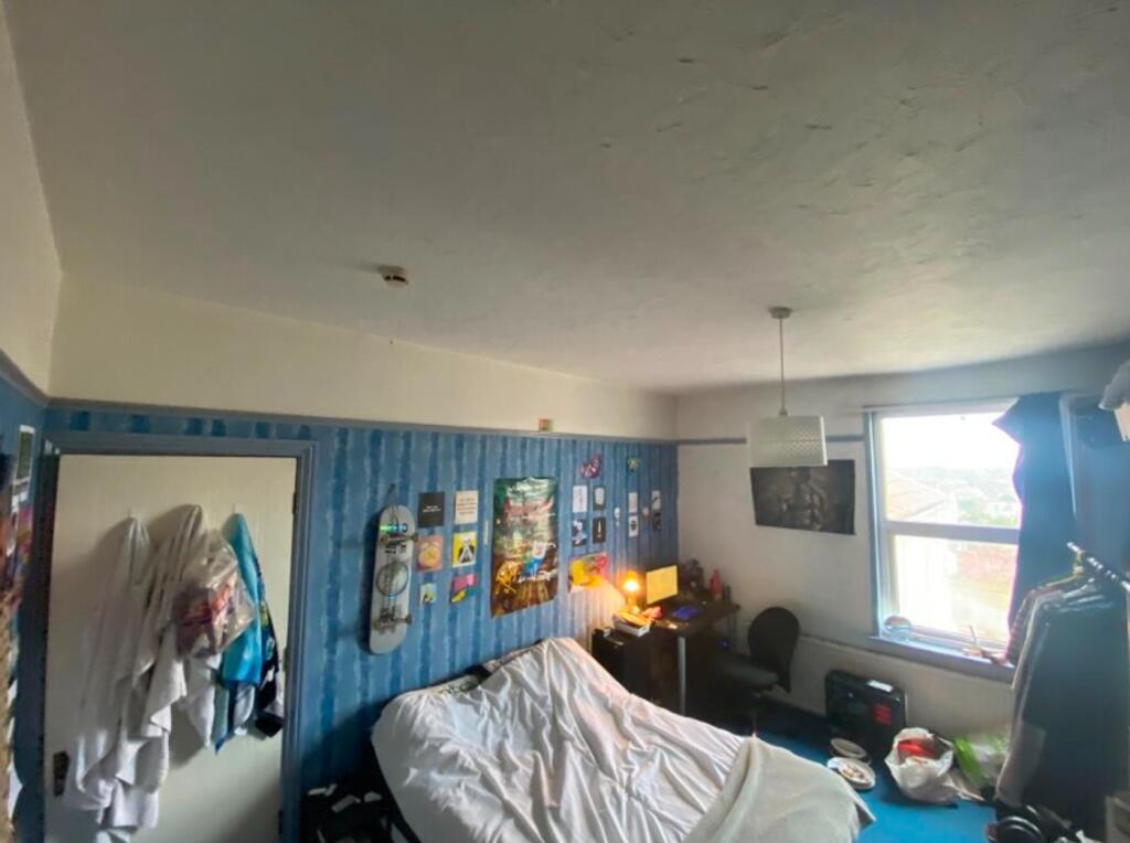 A spacious double bedroom with a cozy atmospher...