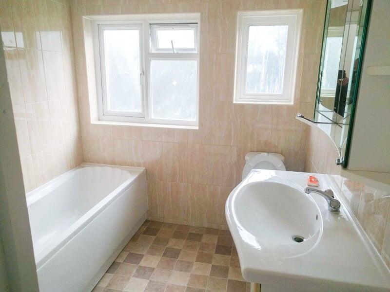 Bright and clean bathroom suite featuring a mod...