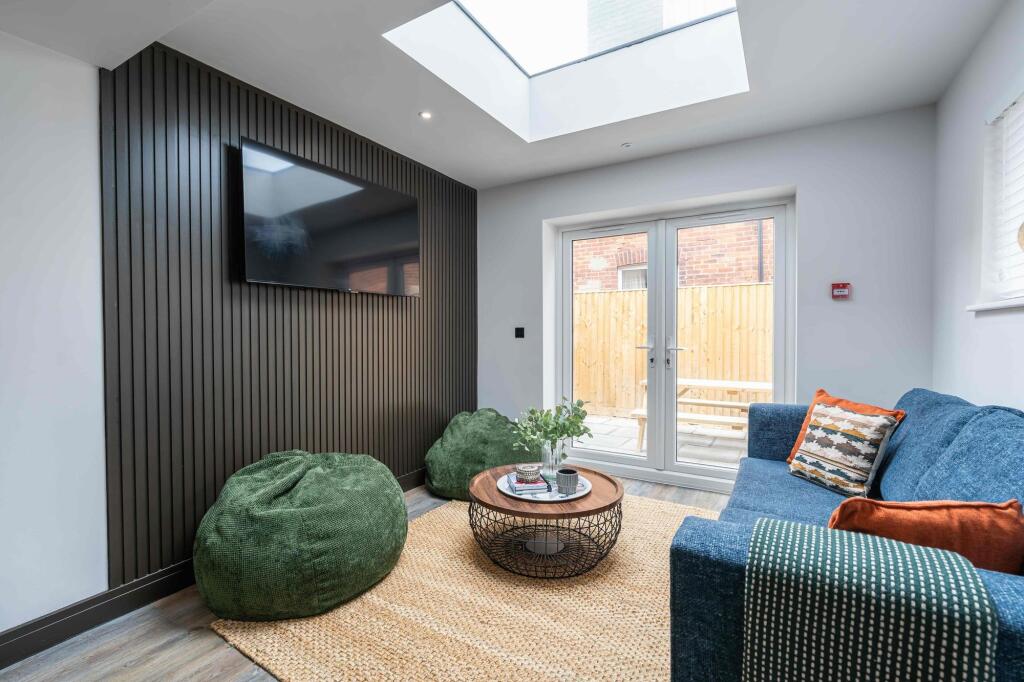 Bright and modern living room featuring a large...