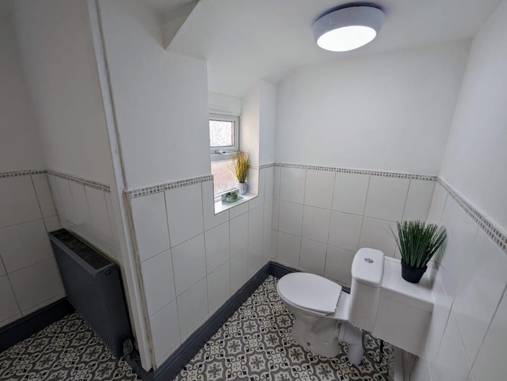 Bright and clean single toilet room featuring p...