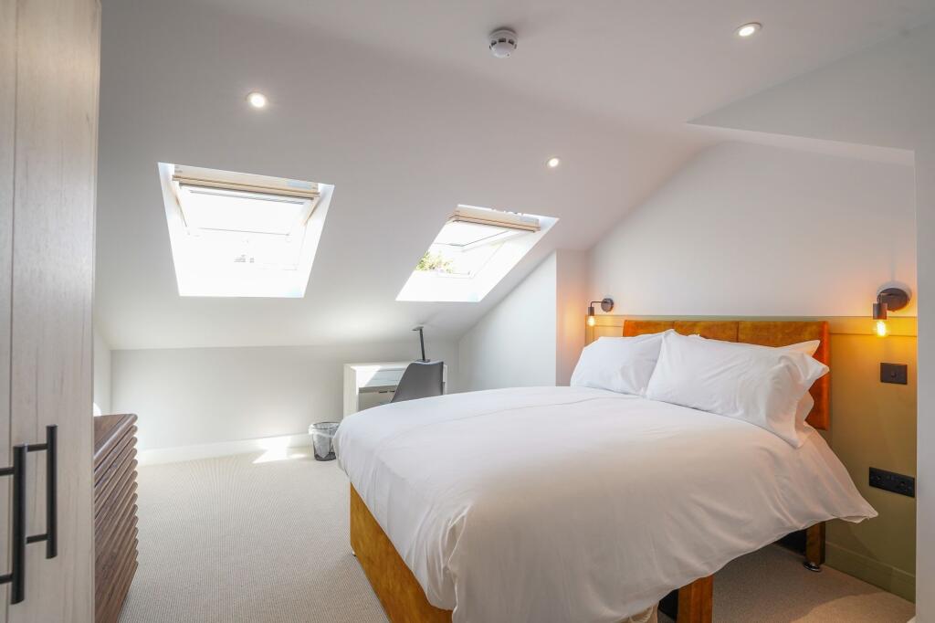 Bright and inviting bedroom with natural sunlig...