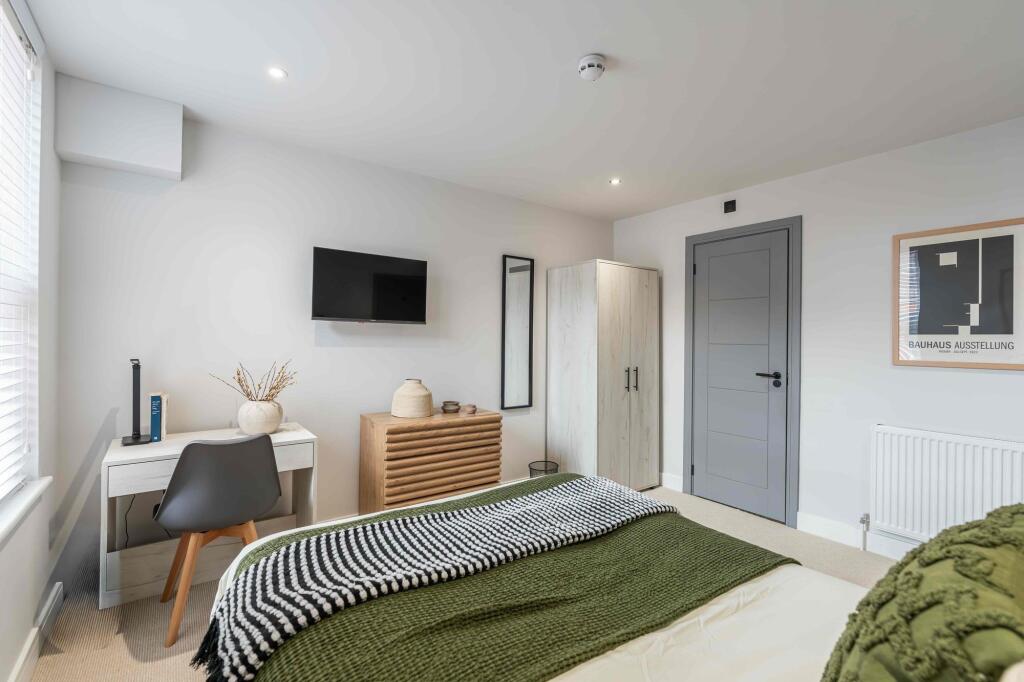 A bright and modern master bedroom featuring a ...