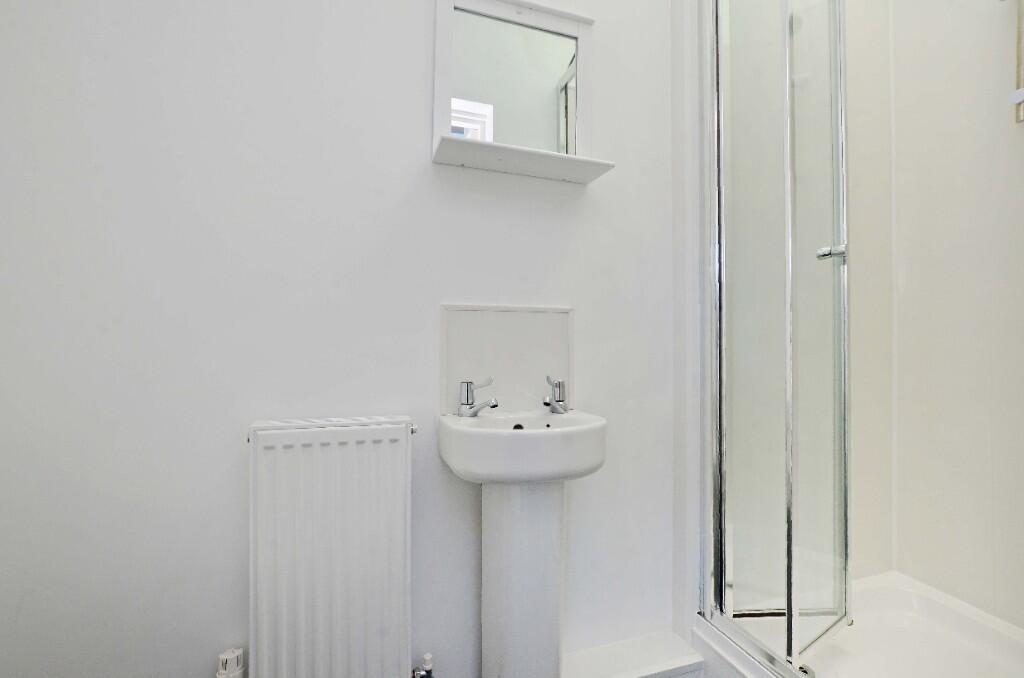 Bright and clean bathroom featuring a modern sh...