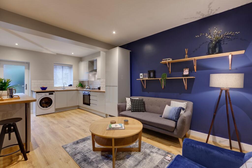 A modern, well-lit living room featuring a comf...