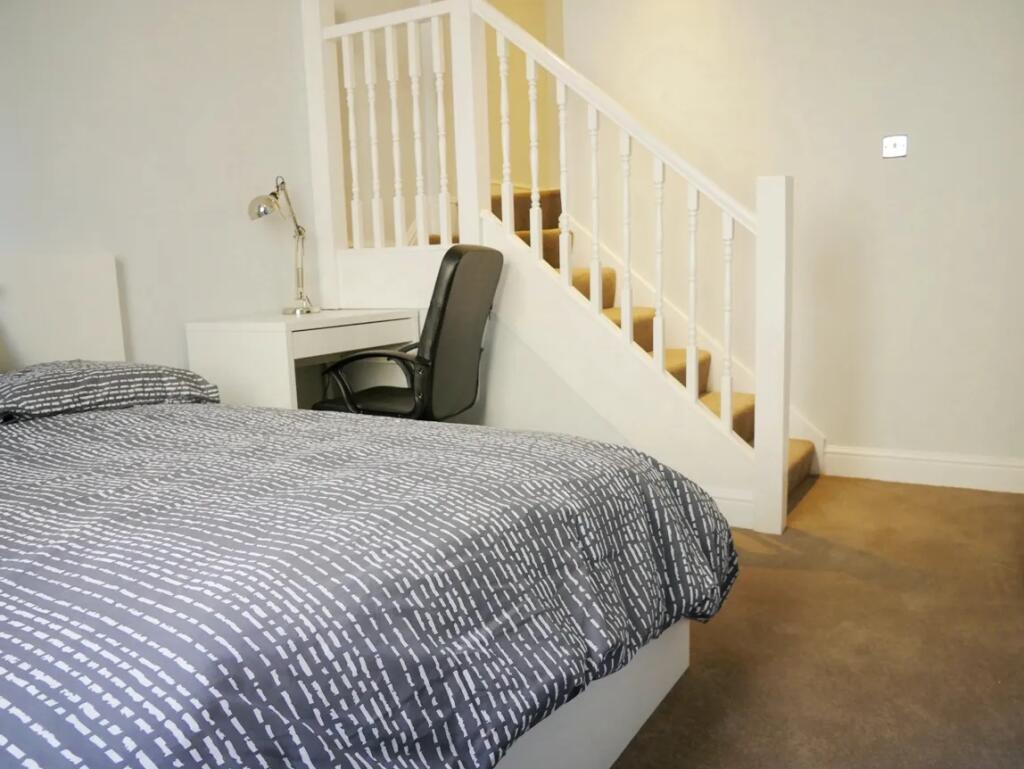 A neat and tidy bedroom featuring a comfortable...
