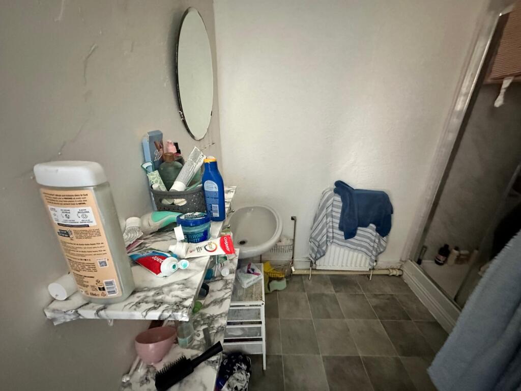 A cozy bathroom featuring a shower and essentia...