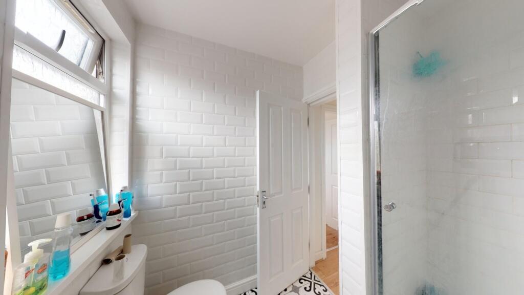 A bright and clean bathroom featuring a glass-e...