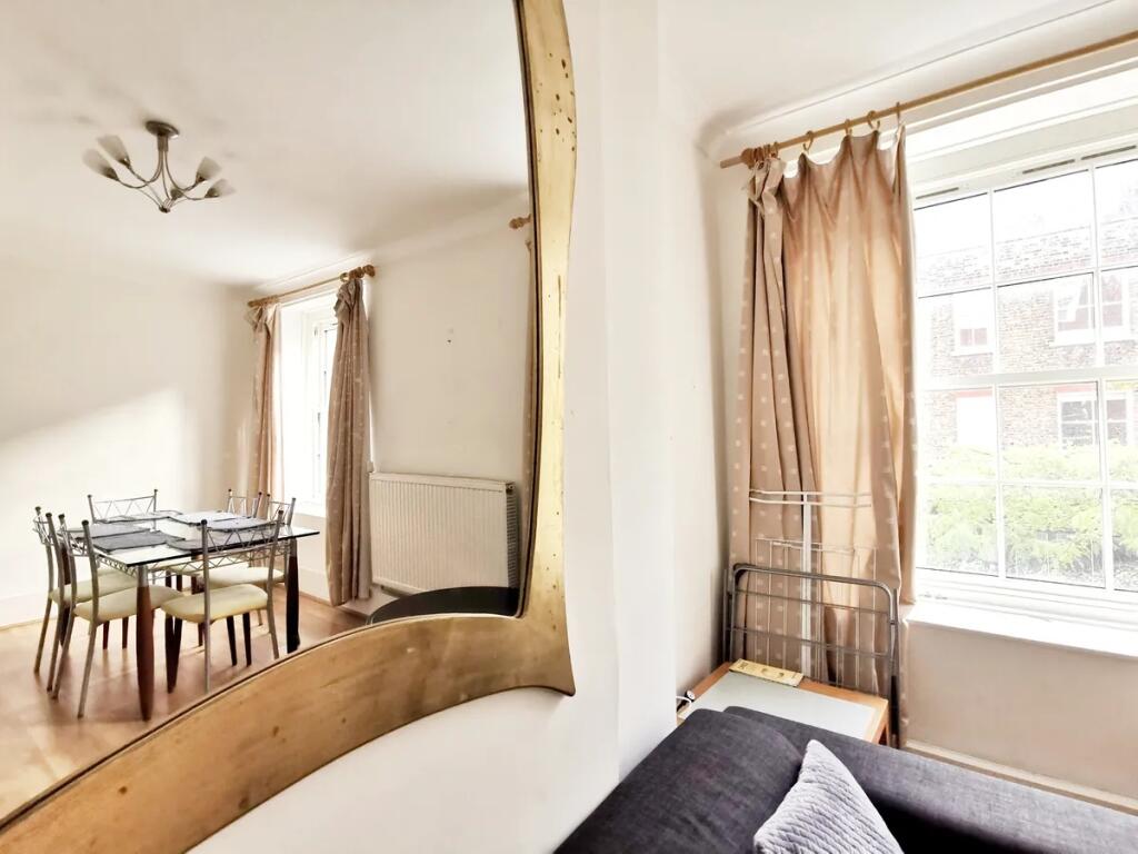 Bright and airy living room featuring a large w...