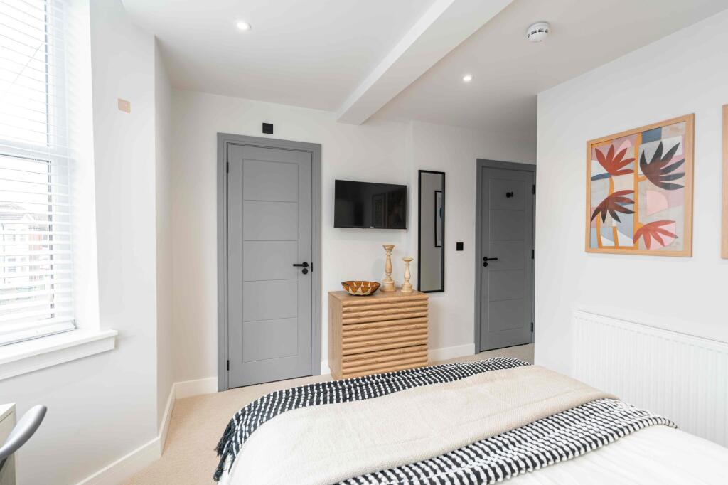 A bright and inviting bedroom featuring a large...