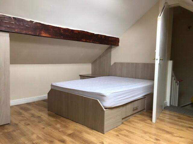 A cozy single bedroom with a comfortable bed an...