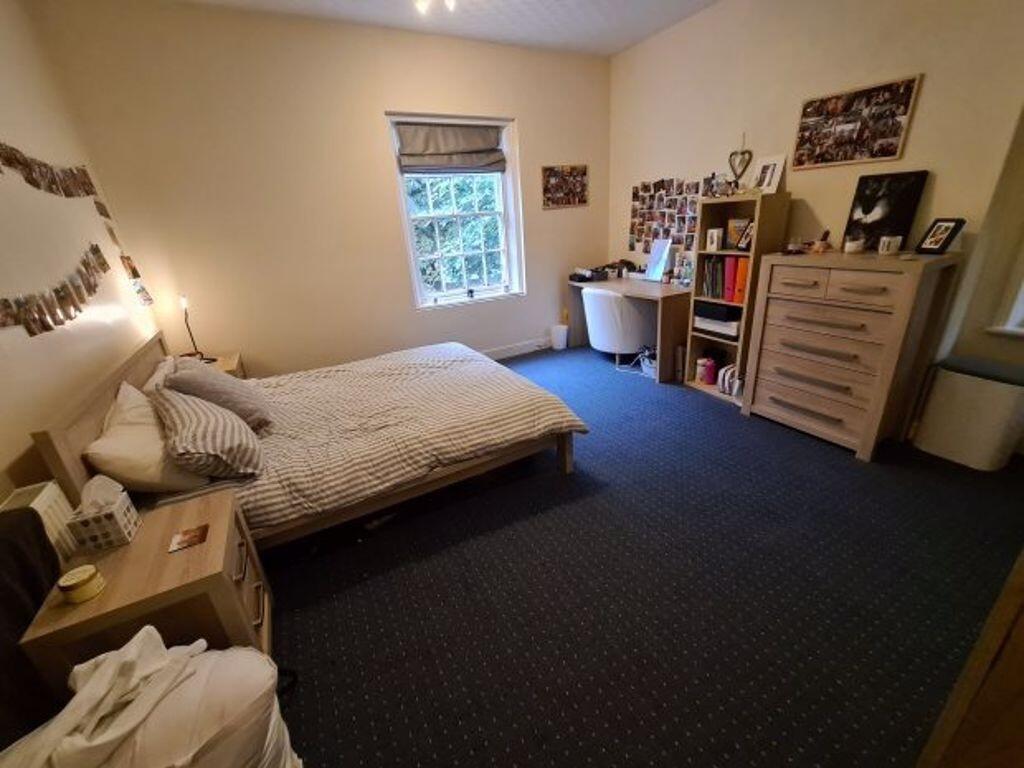 A spacious double bedroom featuring a large bed...