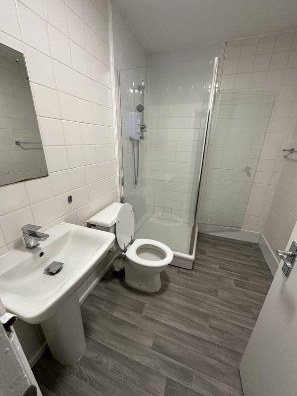 A clean and modern bathroom featuring a walk-in...