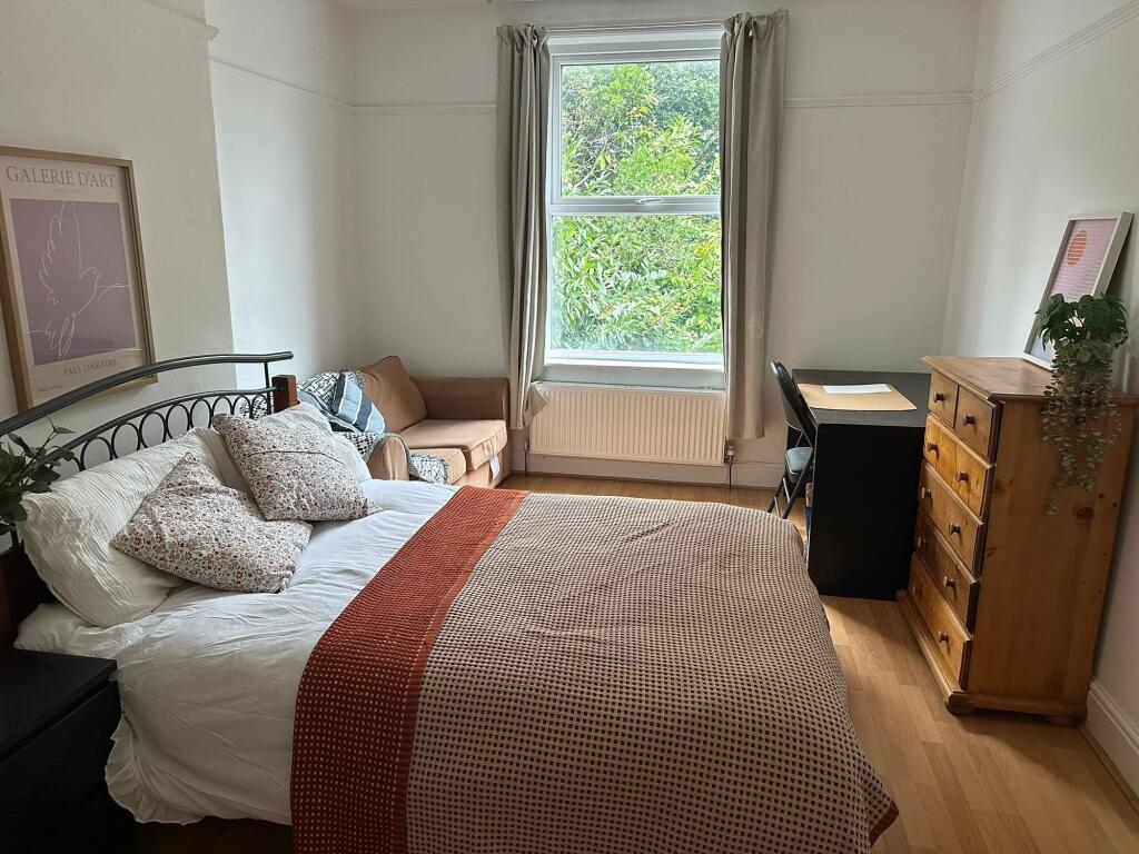 A well-lit, cozy living room with a large windo...