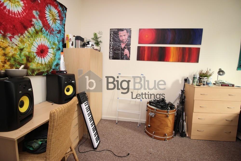 A cozy and vibrant single bedroom featuring col...