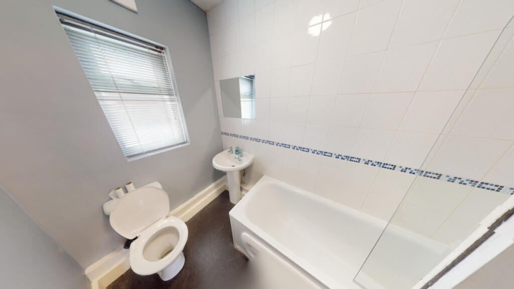 A bright and tidy bathroom featuring a bath and...
