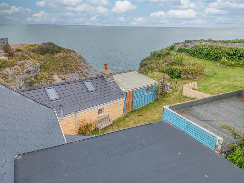 Aerial view out to sea and the stone cottage