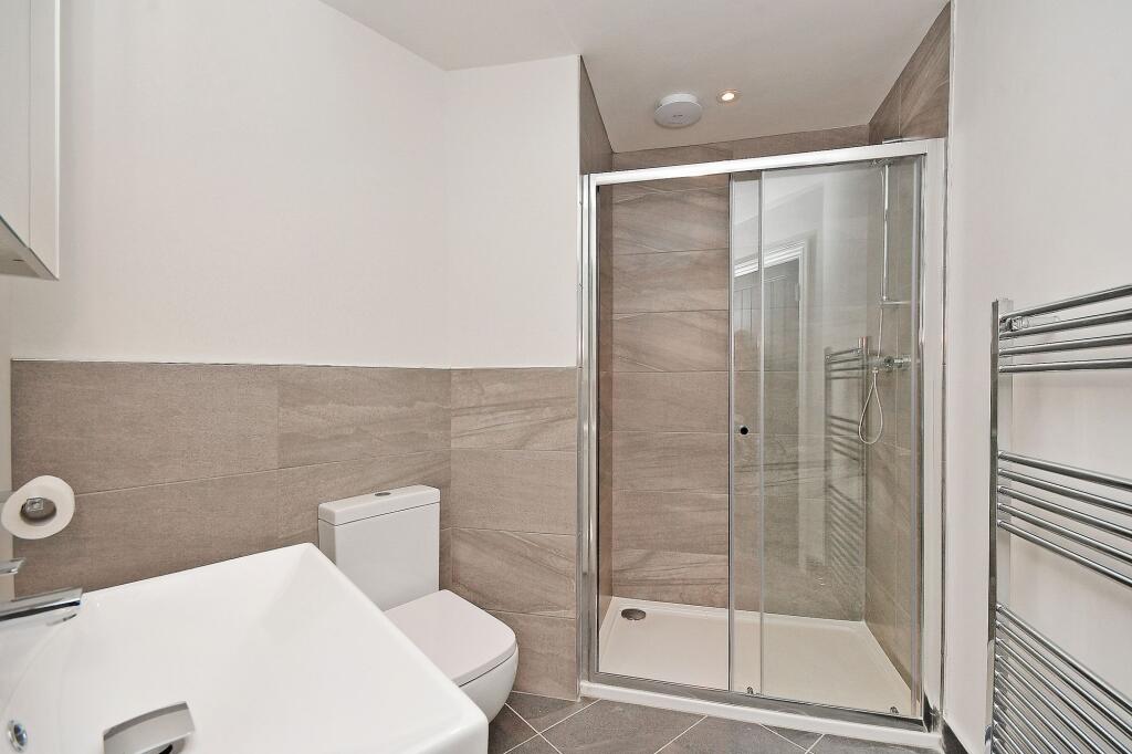 Modern bathroom featuring a walk-in shower with...