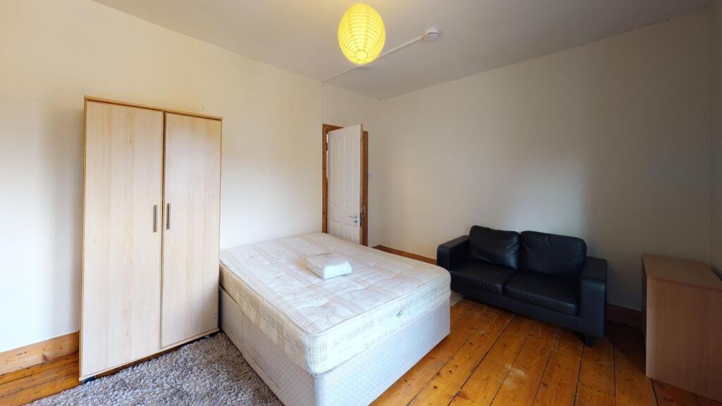 A bright and tidy double bedroom featuring a do...