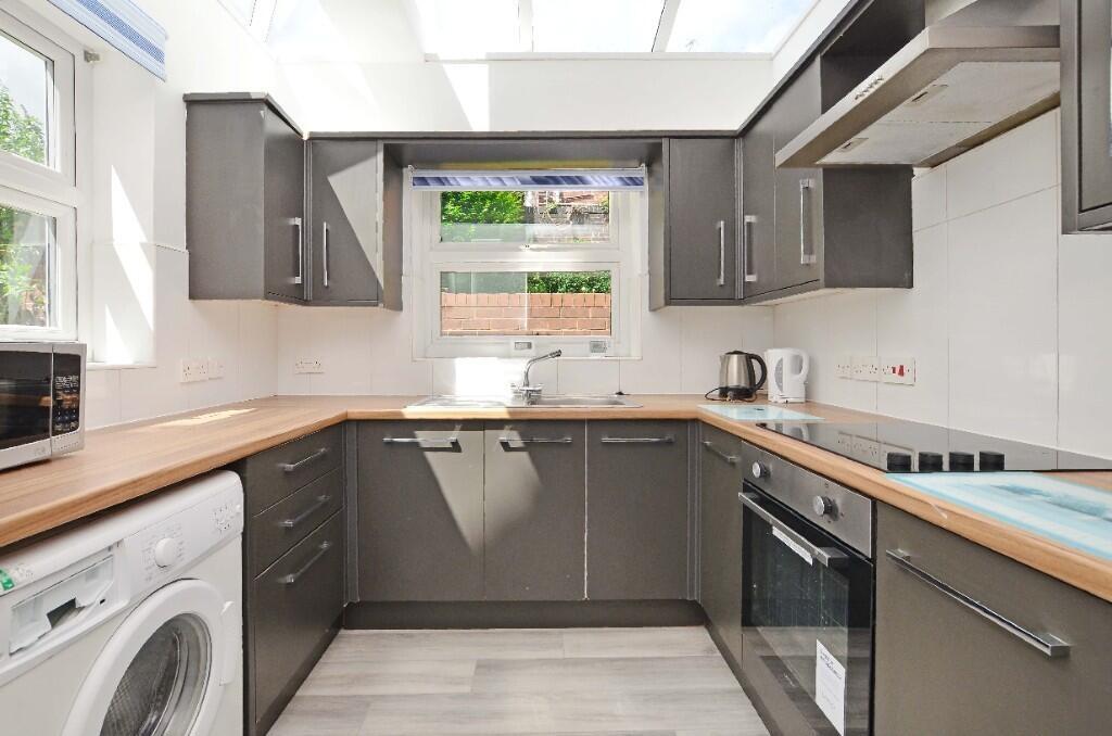 A modern kitchen featuring sleek grey cabinetry...