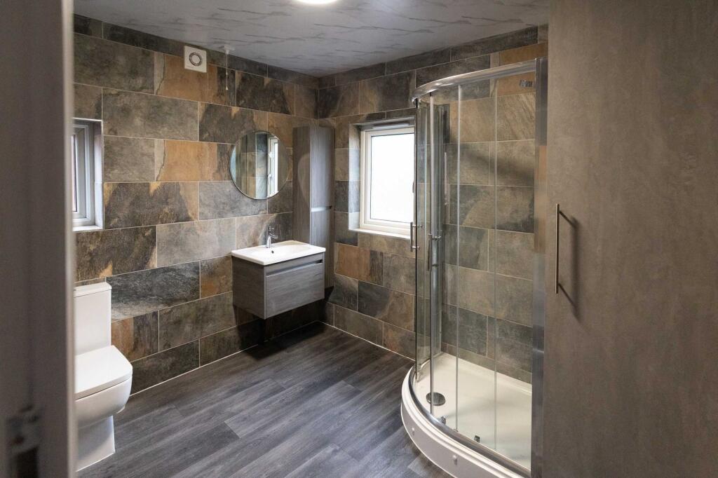 Modern bathroom featuring a walk-in shower with...