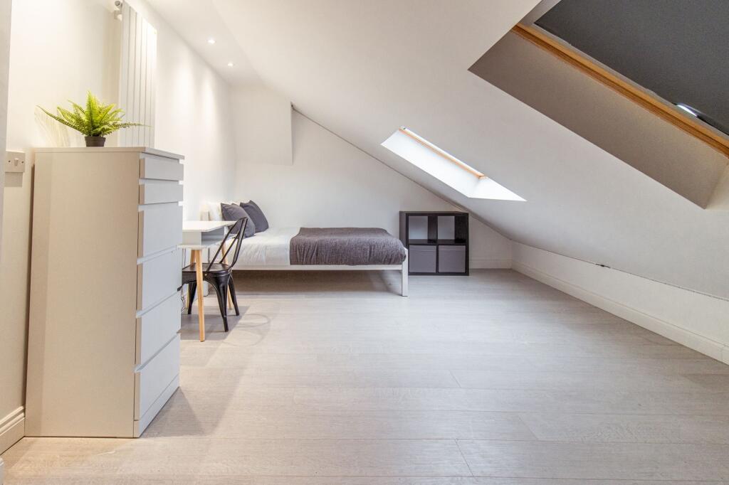 Bright, minimalist attic double bedroom with a ...