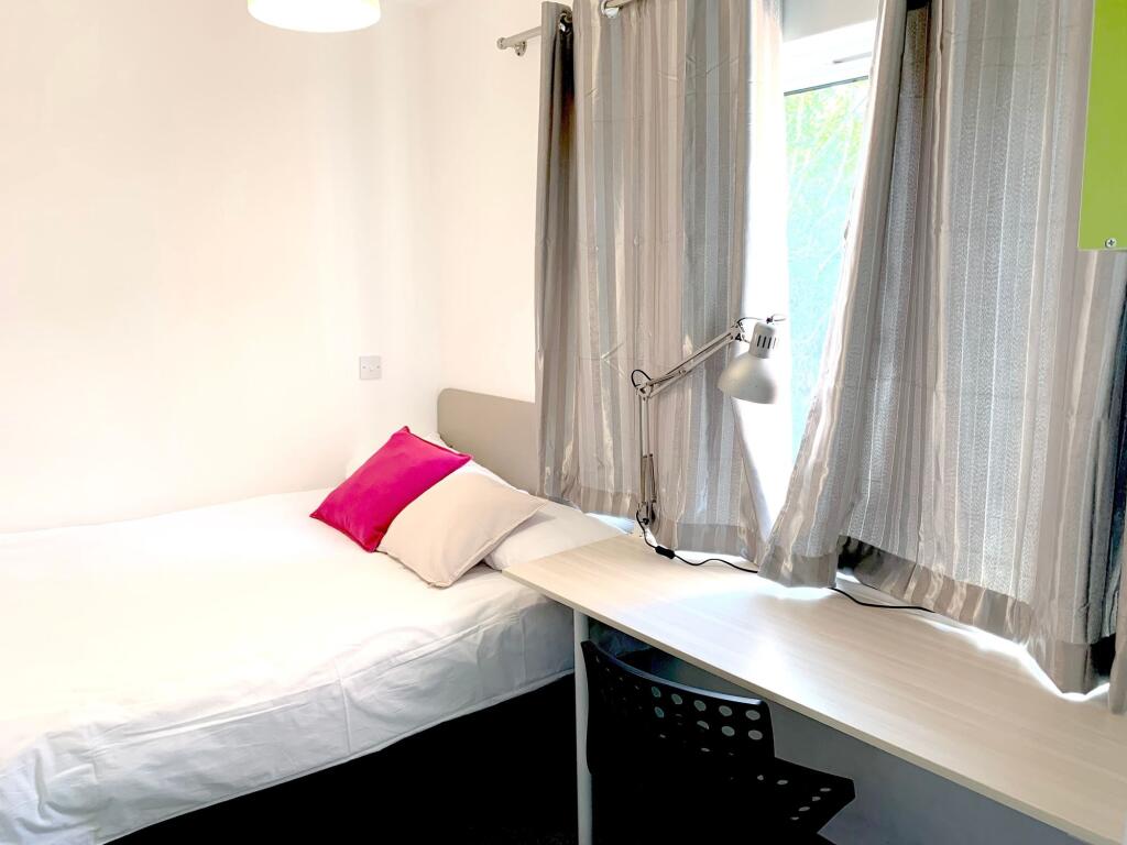 A bright and tidy single bedroom featuring a co...