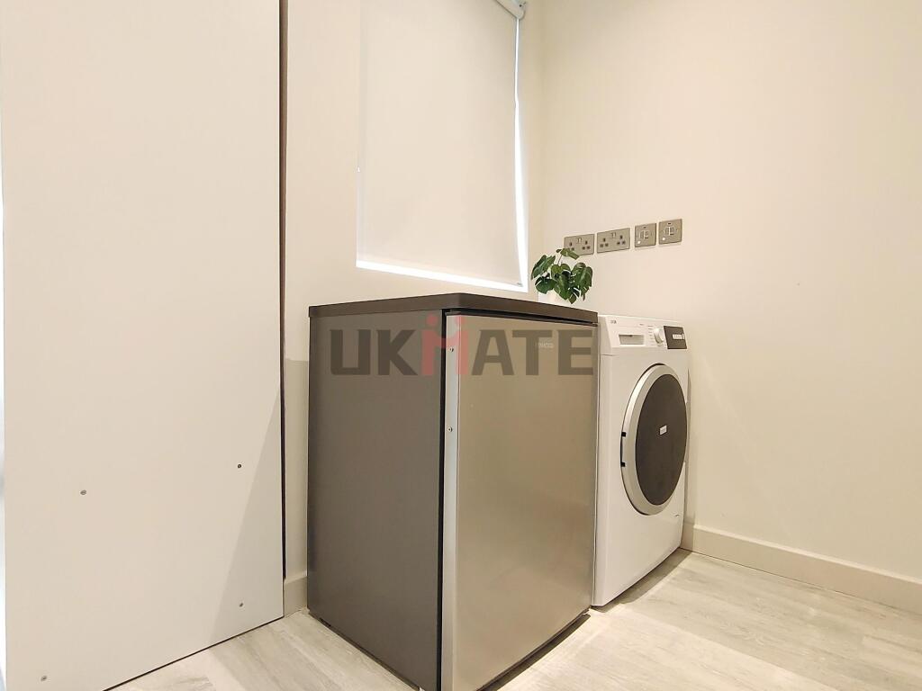 A modern, minimalist kitchen area featuring a w...