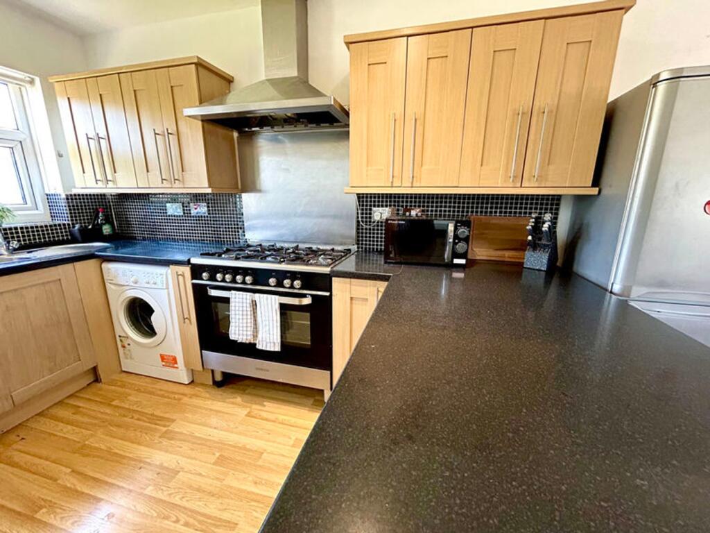 A spacious and modern kitchen featuring sleek c...