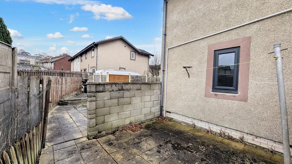 Flagged garden that wraps around the rear of the property