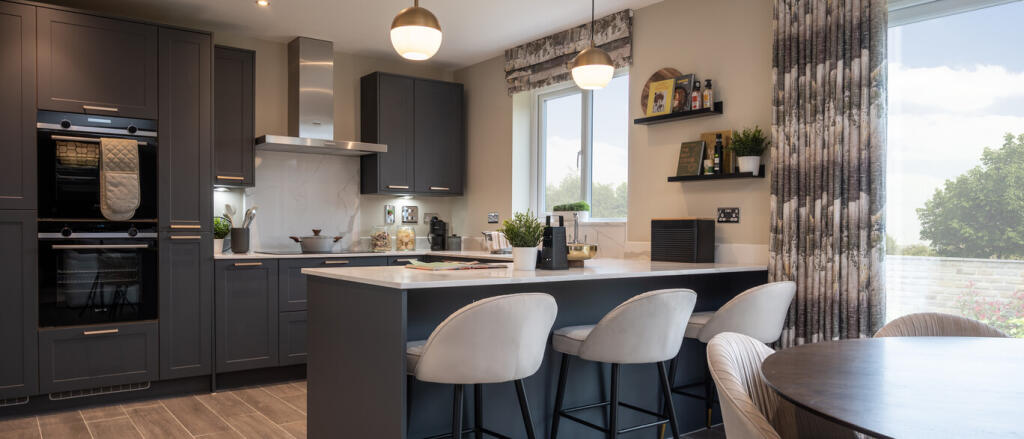 Modern kitchen with dark grey cabinets, white marble backsplash, island with bar stools, and large w