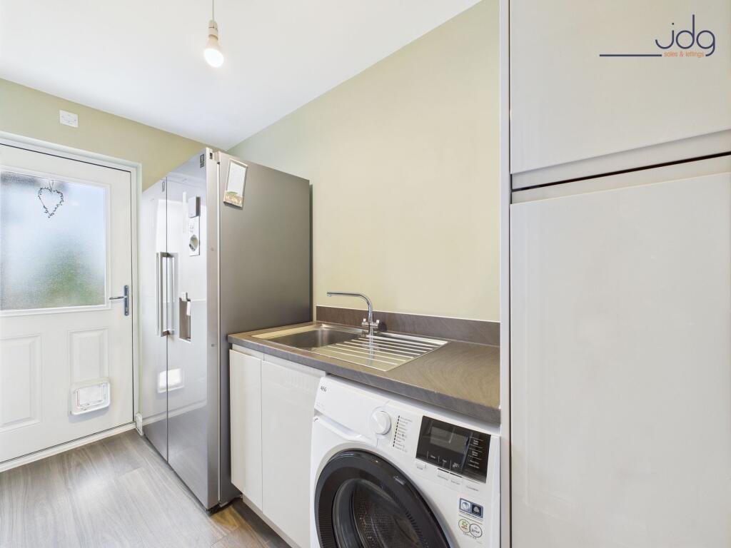 Separate utility room mirrors the kitchen units and gives internal access to the garage