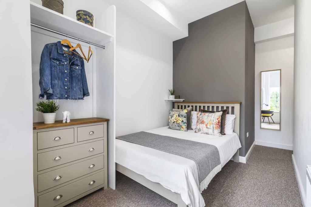 A clean and bright single bedroom with a neatly...