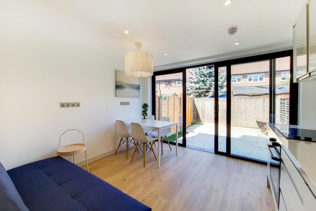 Bright and spacious living room featuring large...