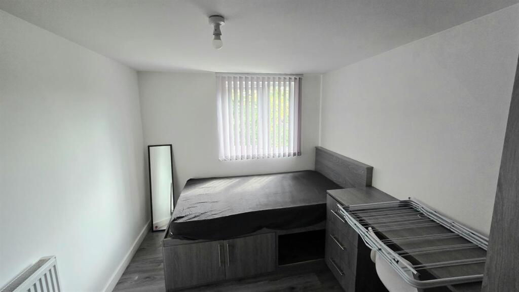 Bright, simply furnished bedroom with a double ...