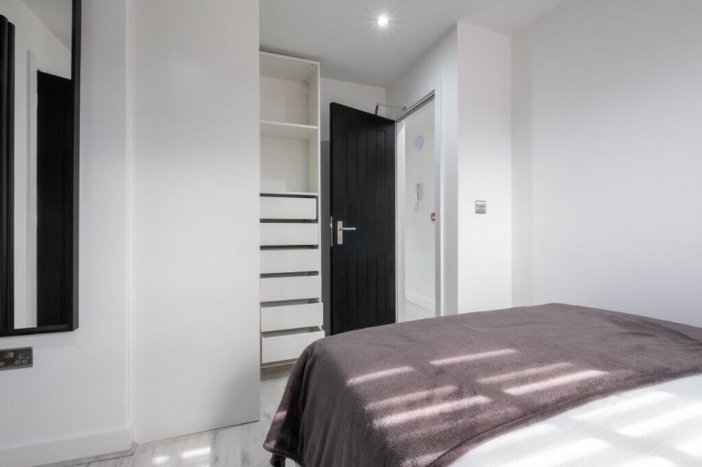 A bright and clean double bedroom featuring mod...